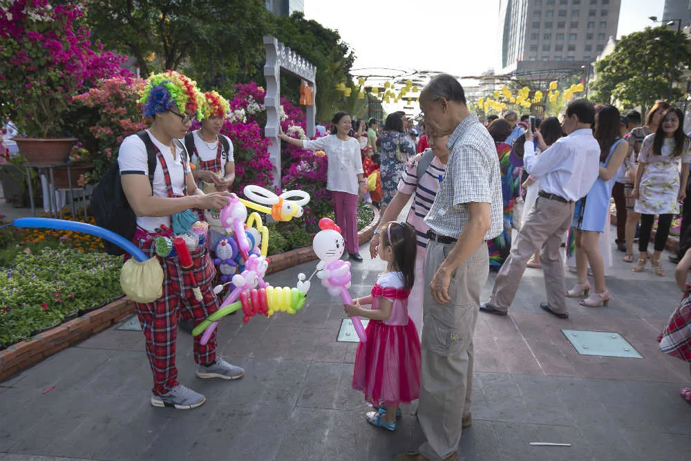 Families on a flower-decorated street in Vietnam in the days before Tet